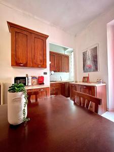 uma cozinha com armários de madeira e uma mesa com uma planta em Bella House, a 200 metri dalla metropolitana em Turim