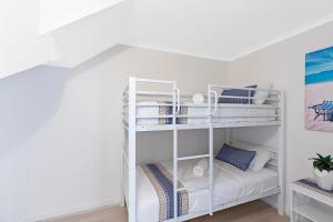 a white bunk bed in a white room at Pacific Breeze 11 in Blue Bay 