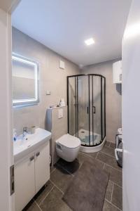uma casa de banho com um chuveiro, um WC e um lavatório. em Bozena's studio apartment em Split
