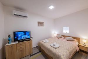 um quarto com uma cama e uma televisão de ecrã plano em Bozena's studio apartment em Split