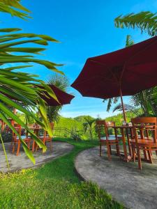 a group of chairs and umbrellas on a path at dbelish village & resto in batumadeg