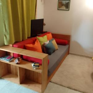 KAZA CHARLY F2 في ليه أبيم: أريكة مع وسائد ملونة في غرفة المعيشة