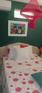 Un dormitorio con una cama con flores rojas. en KAZA CHARLY STUDIO, en Les Abymes