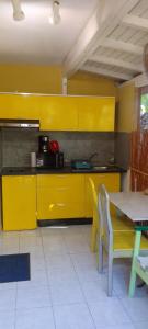 una cucina con armadi gialli, tavolo e sedie di KAZA CHARLY STUDIO a Les Abymes