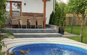 a swimming pool with a table and chairs in a yard at Beautiful Home In Koscierzyna With Wifi in Kościerzyna