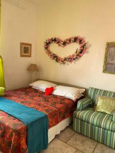 1 dormitorio con 1 cama y una corona de flores en la pared en Casa Caiçara no Caborê, en Paraty