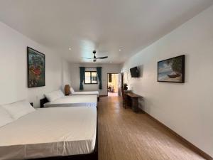 um quarto de hotel com duas camas e um sofá em Mi Nhon Em Hotel Muine em Mui Ne