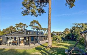 a large black house with a tree at Beautiful Home In Nex With Wifi in Snogebæk