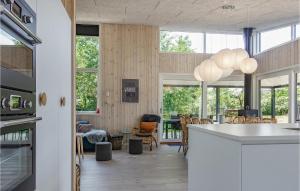 a kitchen and dining room with wood paneling and windows at Beautiful Home In Nex With Wifi in Snogebæk