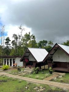 BatuanにあるROCA'S HOMESTAY Backpackers Chalet Boholの二重屋根と庭のある家
