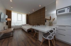 a kitchen and living room with a table and chairs at VICTORY-30 LUXURY APARTMENT CEnTER in Kyiv