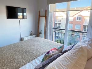 1 dormitorio con cama y ventana grande en Puerto Varas, Departamento céntrico dos personas Yourhomepv en Puerto Varas