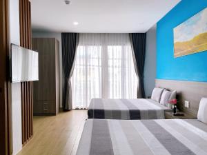 a hotel room with two beds and a window at HÀO PHÁT HOTEL NHA TRANG in Nha Trang