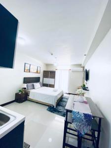 1 dormitorio con 1 cama y lavamanos. en Saekyung 956 Condominium with Balcony, en Lo-oc