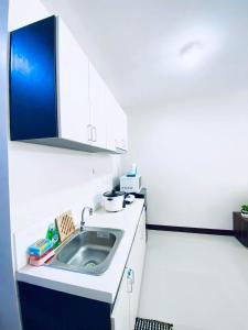 cocina blanca con fregadero en Saekyung 956 Condominium with Balcony, en Lo-oc