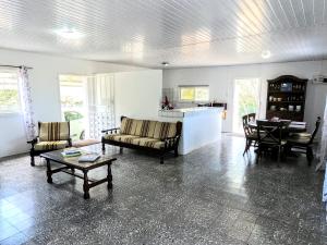 een woonkamer met een bank, stoelen en een tafel bij Traditional Aruban Home close to Surfside Beach in Oranjestad