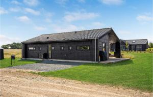 un gran edificio de madera con un patio de césped en Beautiful Home In Fllenslev With Wifi, en Føllenslev
