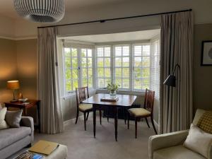un soggiorno con tavolo e finestra di Banksiae a Tackley