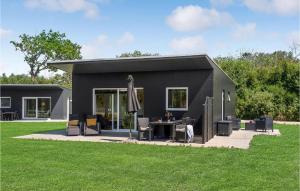 a black tiny house with a table and an umbrella at Cozy Home In Ringkbing With Kitchen in Ringkøbing