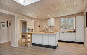 cocina con armarios blancos y techo de madera en Beautiful Home In Vejby With Kitchen, en Vejby