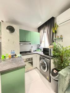 a kitchen with green cabinets and a washing machine at Luxury Studio House 589-3 in 6th Of October