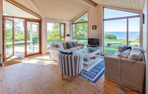 a living room with couches and a tv and glass doors at Gorgeous Home In Nykbing Sj With Kitchen in Ebbeløkke