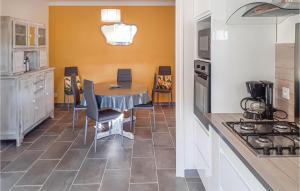 a kitchen with a table and chairs in a kitchen at 3 Bedroom Awesome Home In Saint-carreuc in Plouguenast Langast