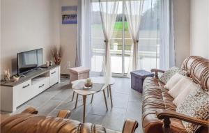 a living room with a couch and a tv at 3 Bedroom Awesome Home In Saint-carreuc in Plouguenast Langast