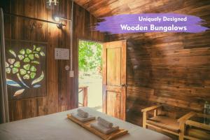 a room with a table with a door and a window at Phu Quoc Valley Sen Bungalow in Phu Quoc