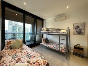 een slaapkamer met 2 stapelbedden en een balkon bij Prima Tower Apartment Face to Crown by GoodLive in Melbourne