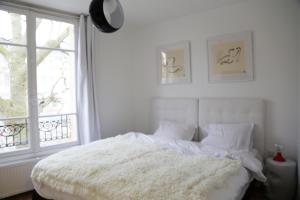 Postel nebo postele na pokoji v ubytování Les Suites de Vanves - Parc des expositions Porte de Versailles
