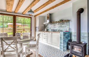 cocina con fogones, mesa y sillas en Lovely Home In Gietrzwald With Kitchen, en Gietrzwałd