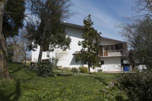 a white house with a balcony and a yard at Il Prato in Predappio