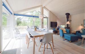 HøjbyにあるGorgeous Home In Hjby With Saunaのダイニングルーム、リビングルーム(テーブル、椅子付)