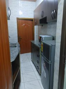 a small kitchen with a stove and a refrigerator at Cozy & Private 1 Bedroom self contained Kigali-Kanombe in Kigali