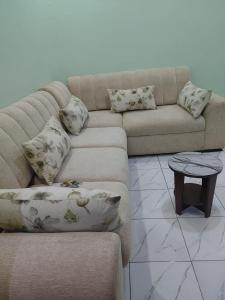 a living room with a couch and a table at Cozy & Private 1 Bedroom self contained Kigali-Kanombe in Kigali