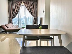 un soggiorno con tavolo da pranzo e sedie di KL City View near DESA PARK Mont Kiara 8-9Pax 中文房东 a Kuala Lumpur