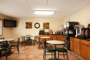 a restaurant with tables and chairs in a room at Super 8 by Wyndham West Fargo Main Ave ND in West Fargo
