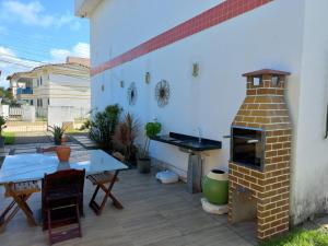 patio z piecem ceglanym i stołem w obiekcie Apartamento Maria Farinha w mieście Maria Farinha