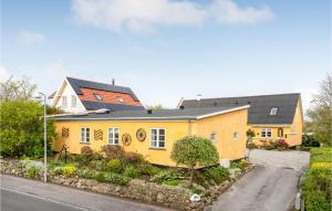 una casa amarilla al lado de una calle en Awesome Home In Hornbk With Kitchen, en Hornbæk