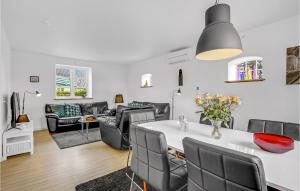 uma sala de estar com uma mesa e cadeiras e um sofá em Awesome Home In Hornbk With Kitchen em Hornbæk