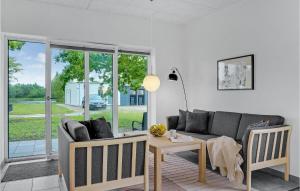 uma sala de estar com um sofá e uma mesa em Lovely Home In Ringkbing With Kitchen em Hee