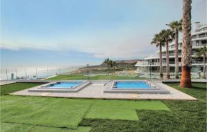 um quintal com duas piscinas e um edifício em Beautiful Apartment In Elche With Kitchenette em Arenales del Sol