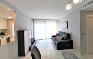 een woonkamer met een zwarte bank en een keuken bij Beautiful Apartment In Elche With Kitchenette in Arenales del Sol