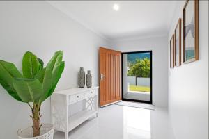 un pasillo con una puerta y una maceta en Whitsunday Holiday Home, en Cannonvale 17 fotos más