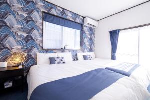 a bedroom with a large bed with a blue and white patterned wall at スカイハウス富士河口湖 in Fujikawaguchiko