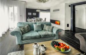 una sala de estar con sofá y un bol de fruta en una mesa en 3 Bedroom Beautiful Home In Zbychowo, en Zbychowo