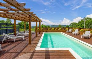 una piscina en una terraza con sillas y pérgola en Amazing Home In Udbina With Indoor Swimming Pool, en Udbina