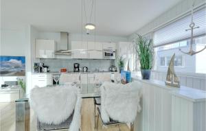 a kitchen with a counter with two white chairs at Biscaya in Olpenitz