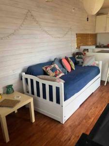 una cama con almohadas y una mesa en una habitación en El Container de la Playa, en Punta del Diablo